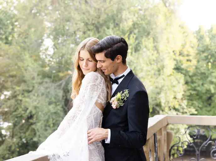 A bride and groom walking through the gardens of Château Diter.