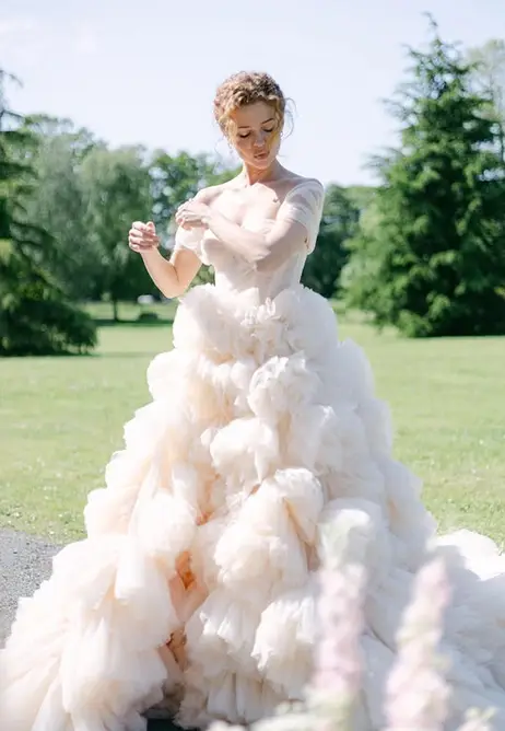 A bride laughing, veil lifted by the wind.