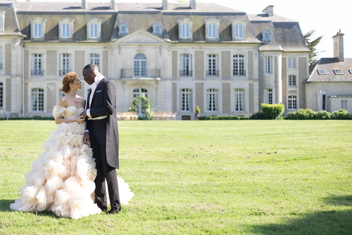 A couple embracing in the golden light of a Riviera garden at the end of the day.
