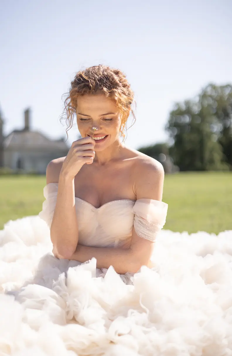 The bride alone in a doorway, her dress falling in long folds.